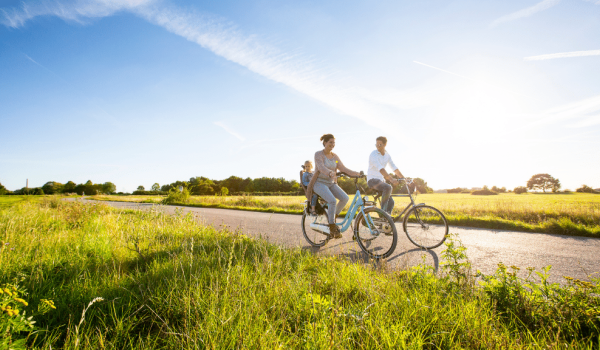 Jong gezin fietsend door groen landschap